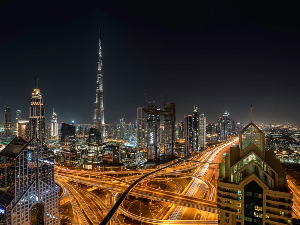 Dubai skyline at night with Burj Khalifa and highways