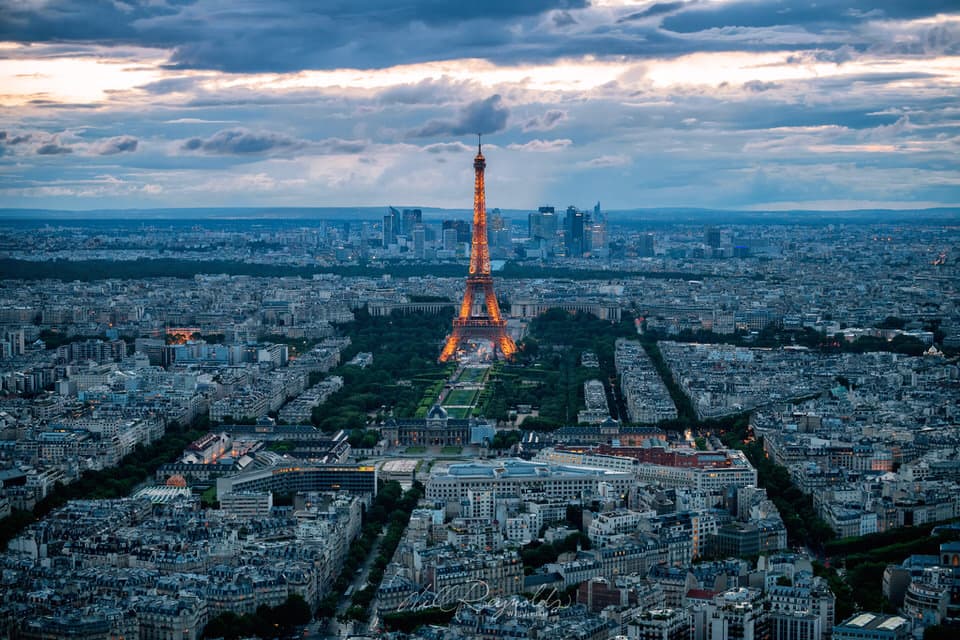 Eiffel Tower illuminated at blue hour overlooking Paris skyline