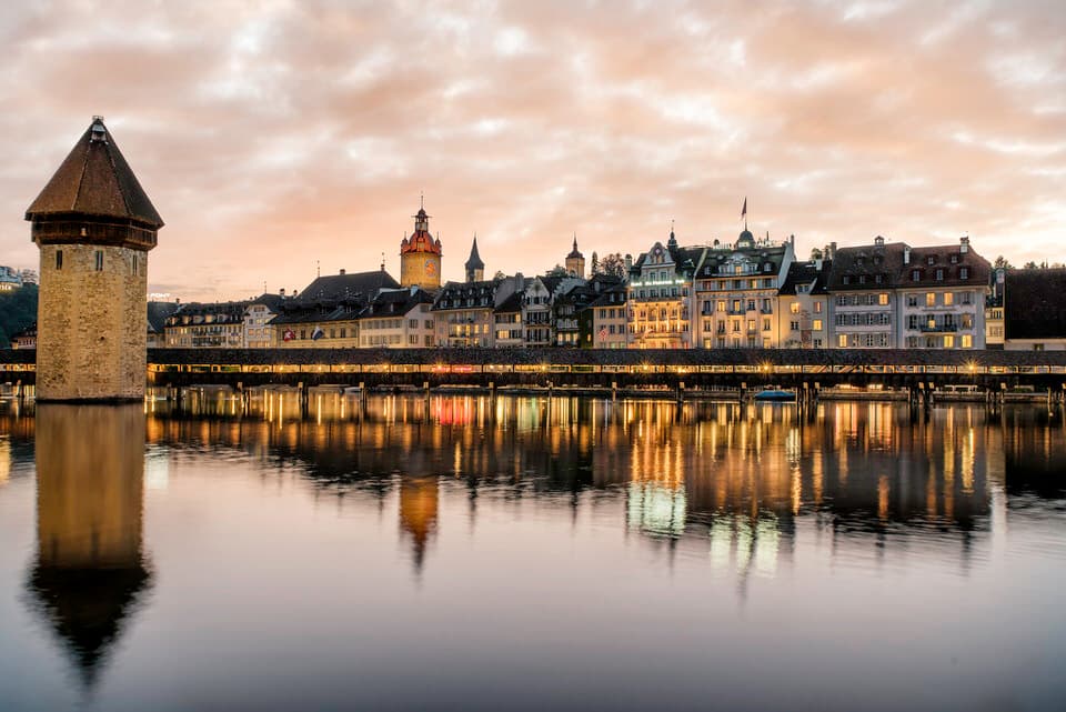 Chapel Bridge reflecting in the river with golden hour sky in Lucerne