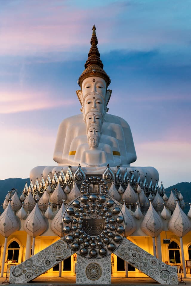 White Buddha statues at Wat Pha Sorn Kaew temple during sunrise