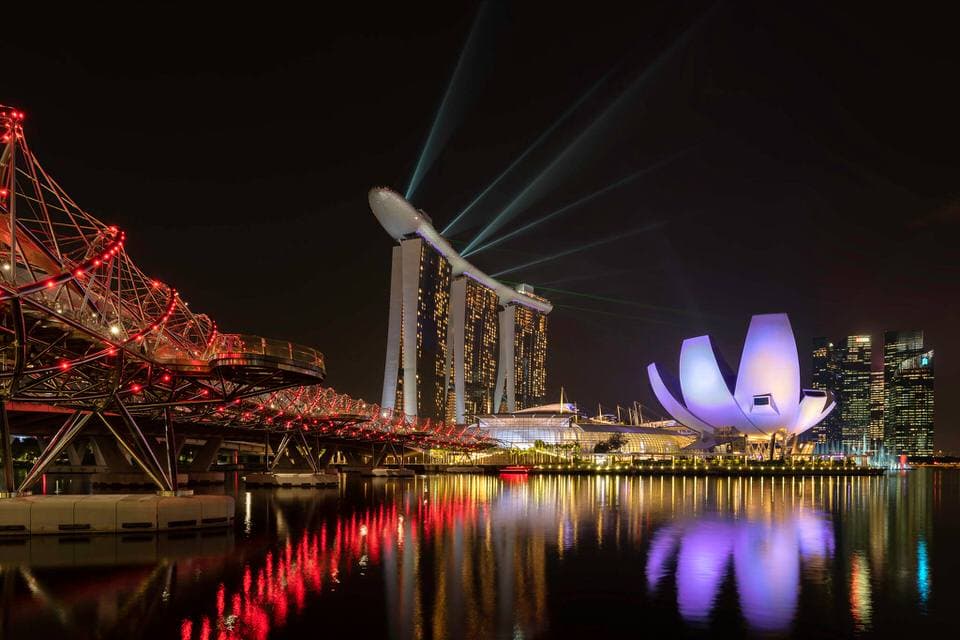 Night view of Marina Bay Sands and Helix Bridge with water reflections