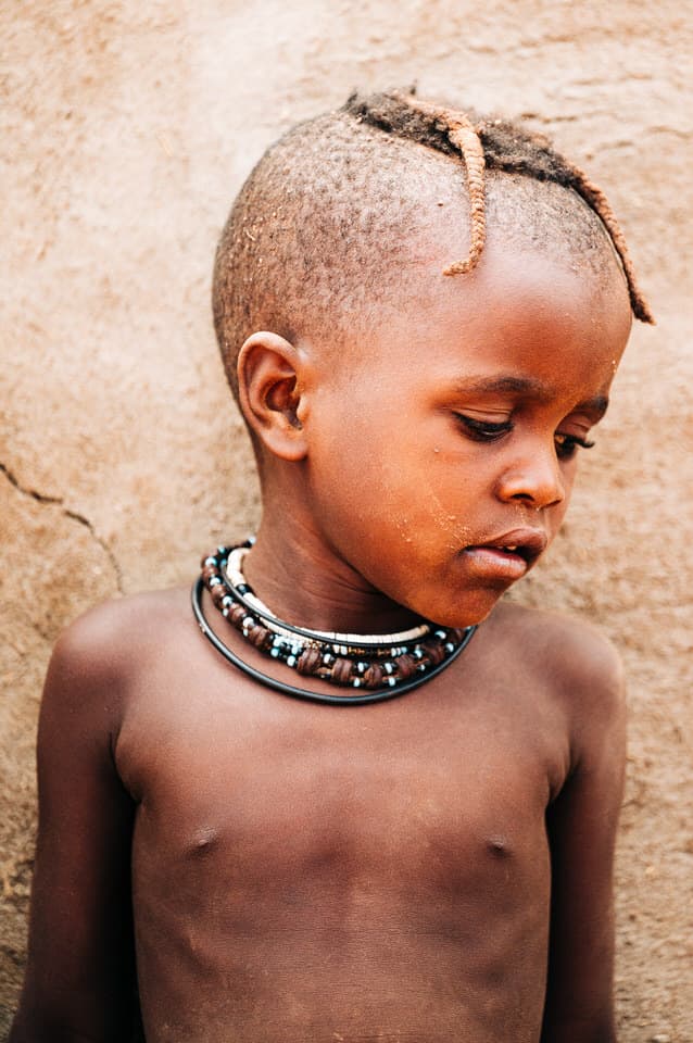 Himba child in Namibia wearing cultural jewelry