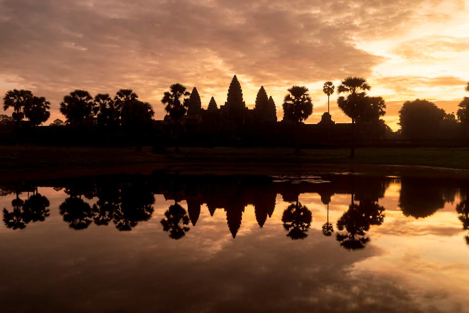 Angkor Wat temple at sunrise with its reflection in the water in Cambodia