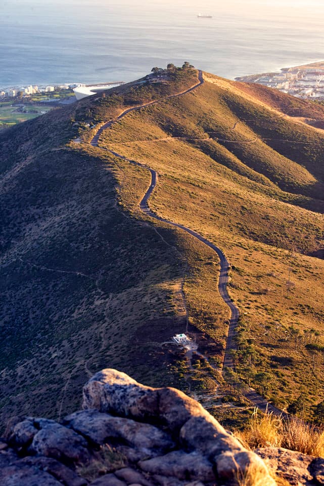 Sunrise over Signal Hill in Cape Town with a winding road and coastal views