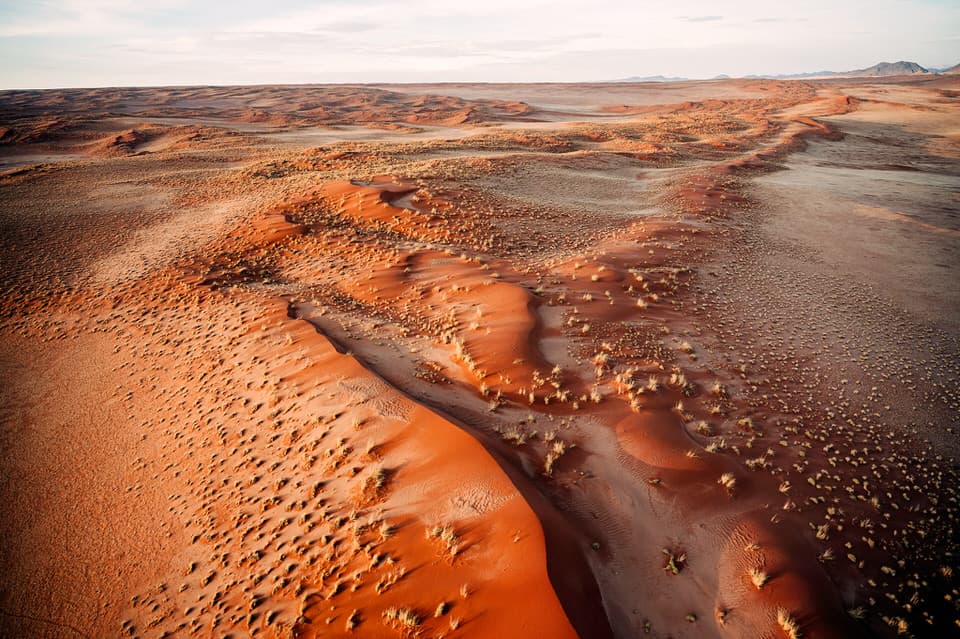 Expansive aerial view of the sand dunes and desert landscape in Sossusvlei, Namibia