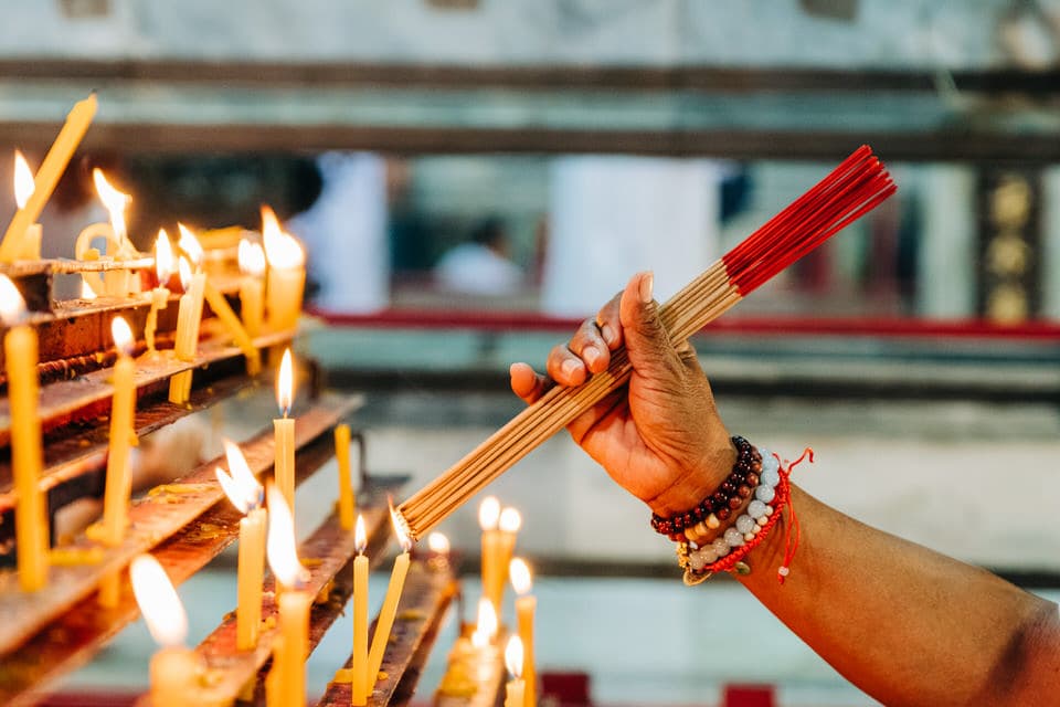 Devotee holding burning incense sticks during the Phuket Vegetarian Festival in Thailand.