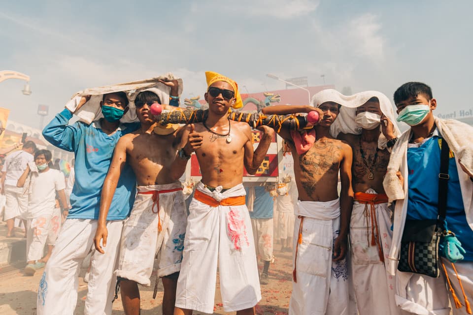 Group of devotees marching amidst firecracker smoke during the Phuket Vegetarian Festival.